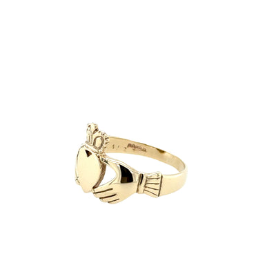 Gold ring with claddagh design on a white background