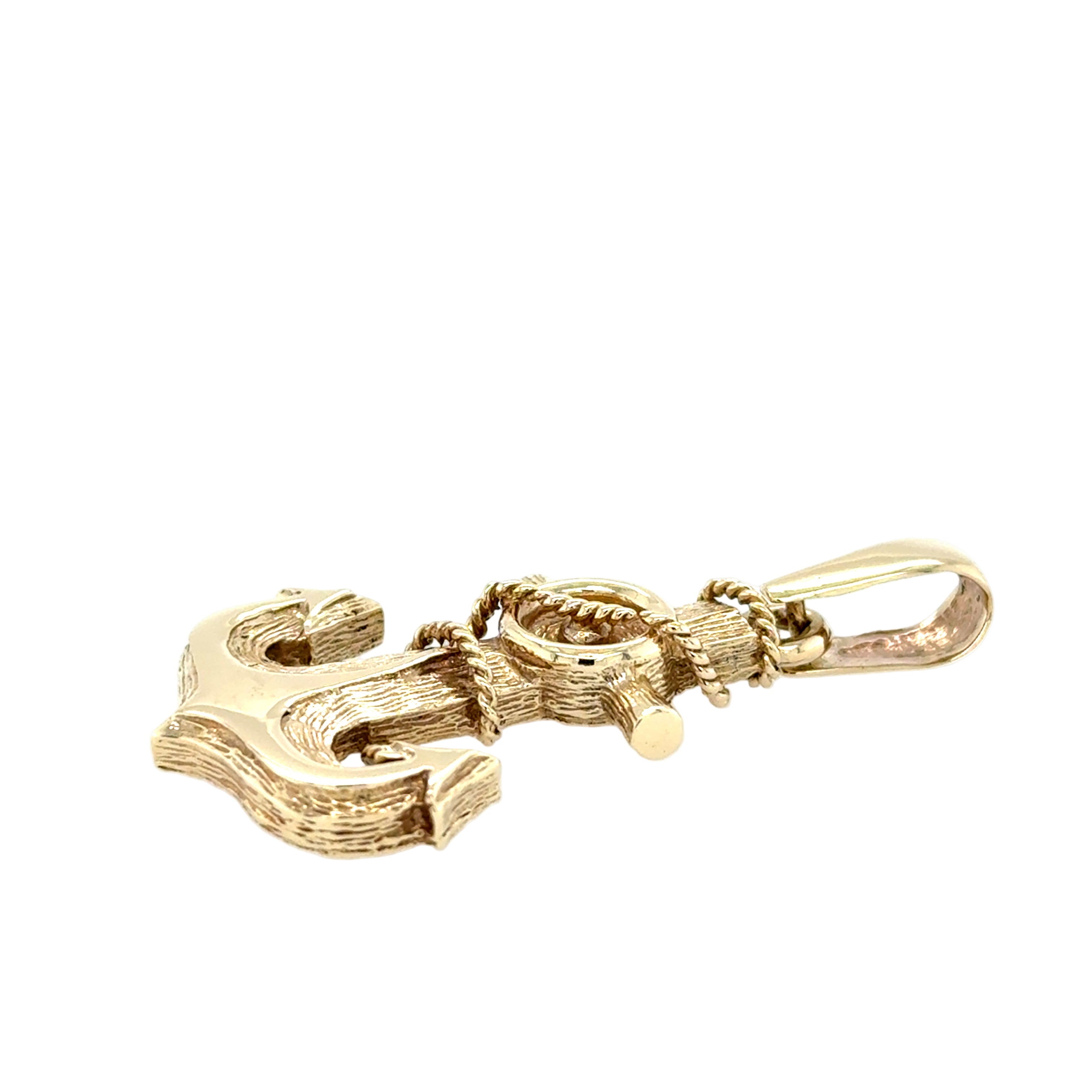 Gold anchor-shaped pendant on a white background